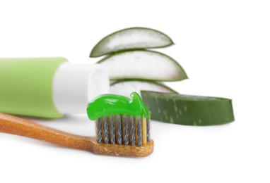 Photo of Toothbrush with toothpaste and green aloe leaves on white background