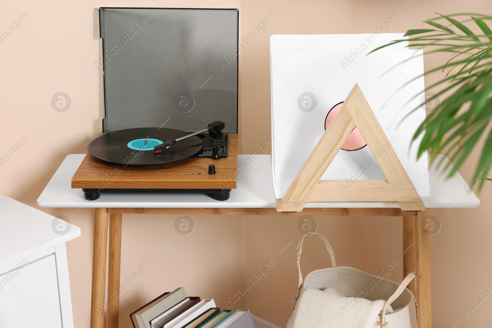 Photo of Stylish turntable with vinyl record on console table in room