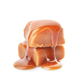 Delicious candies with caramel sauce on white background