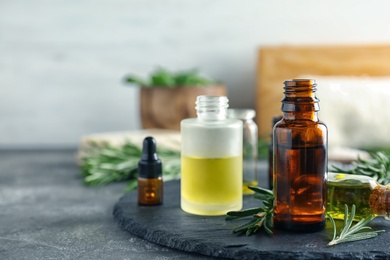 Photo of Bottles with essential oils on slate plate