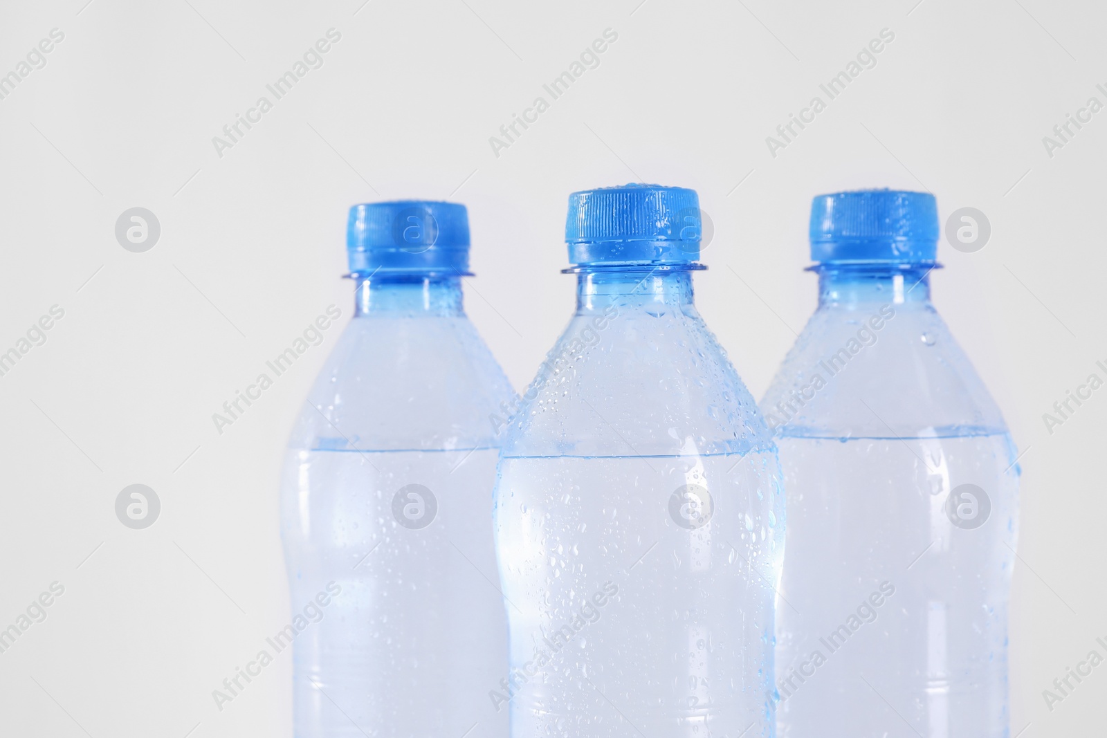 Photo of Plastic bottles with pure water on white background