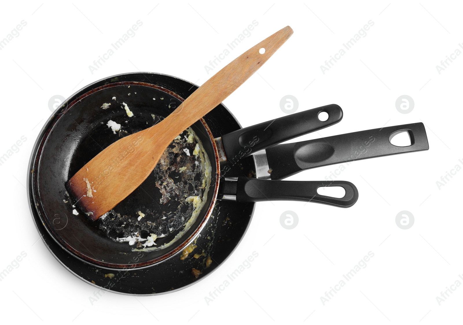 Photo of Dirty frying pans and wooden spatula on white background, top view