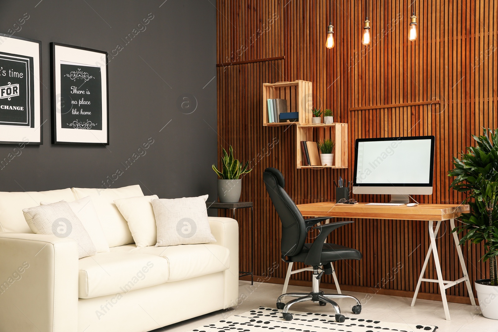 Photo of Comfortable workplace with computer near wooden wall in stylish room interior. Home office design