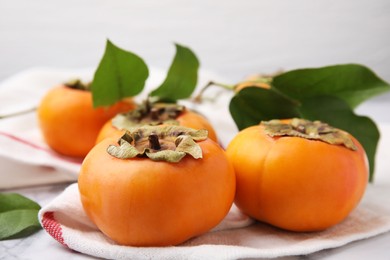 Delicious ripe juicy persimmons on table, closeup