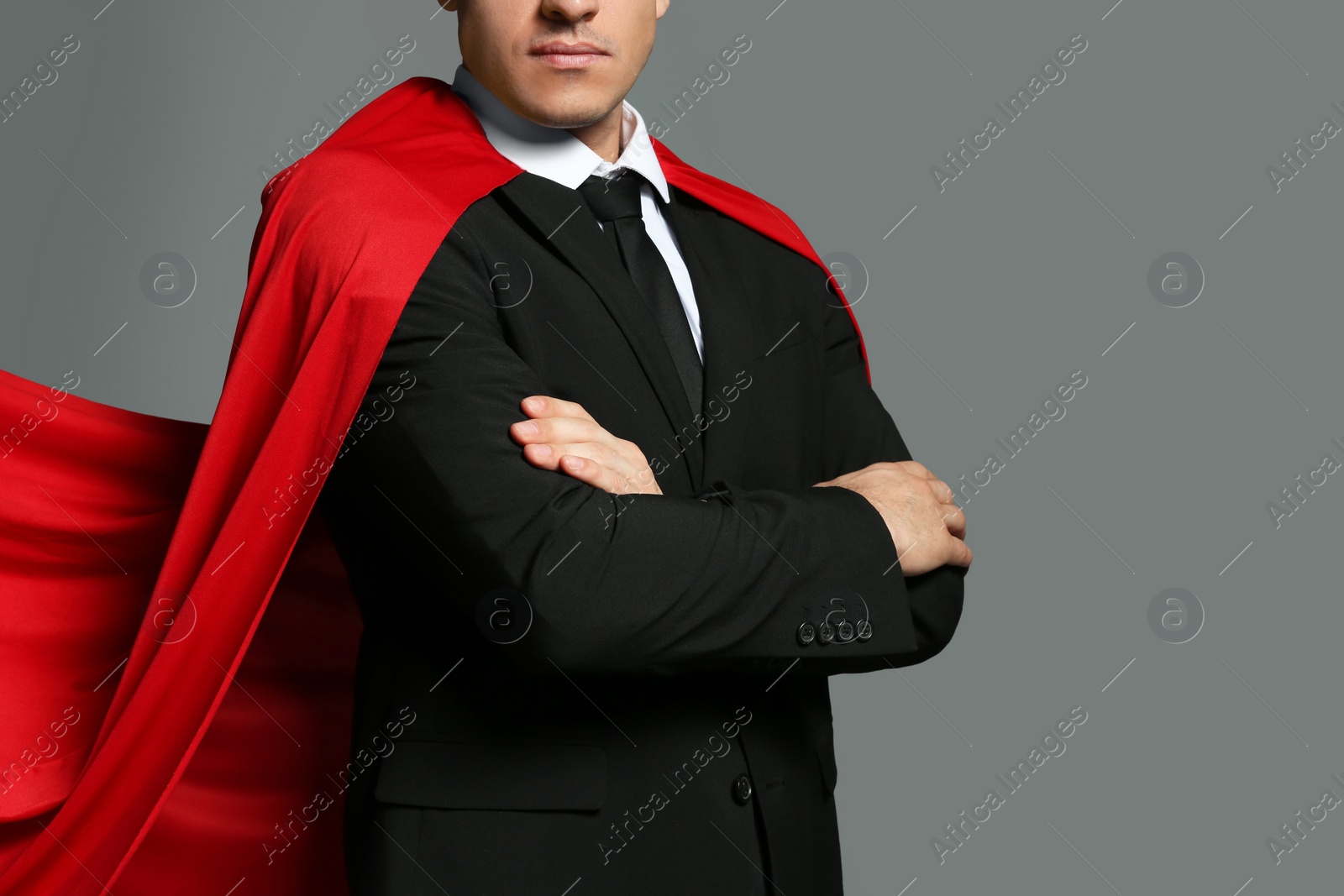 Photo of Businessman wearing superhero cape on grey background, closeup