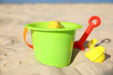 Bright child plastic toys on sandy beach