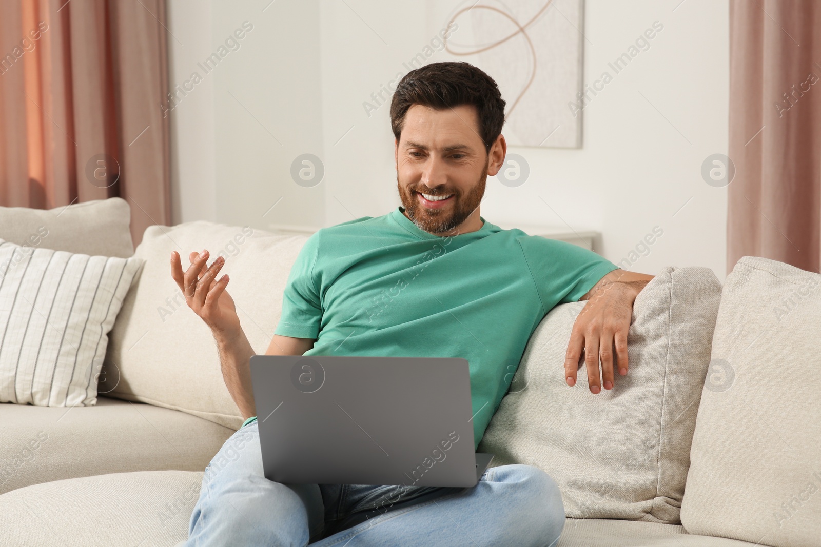 Photo of Man having video chat via laptop at home