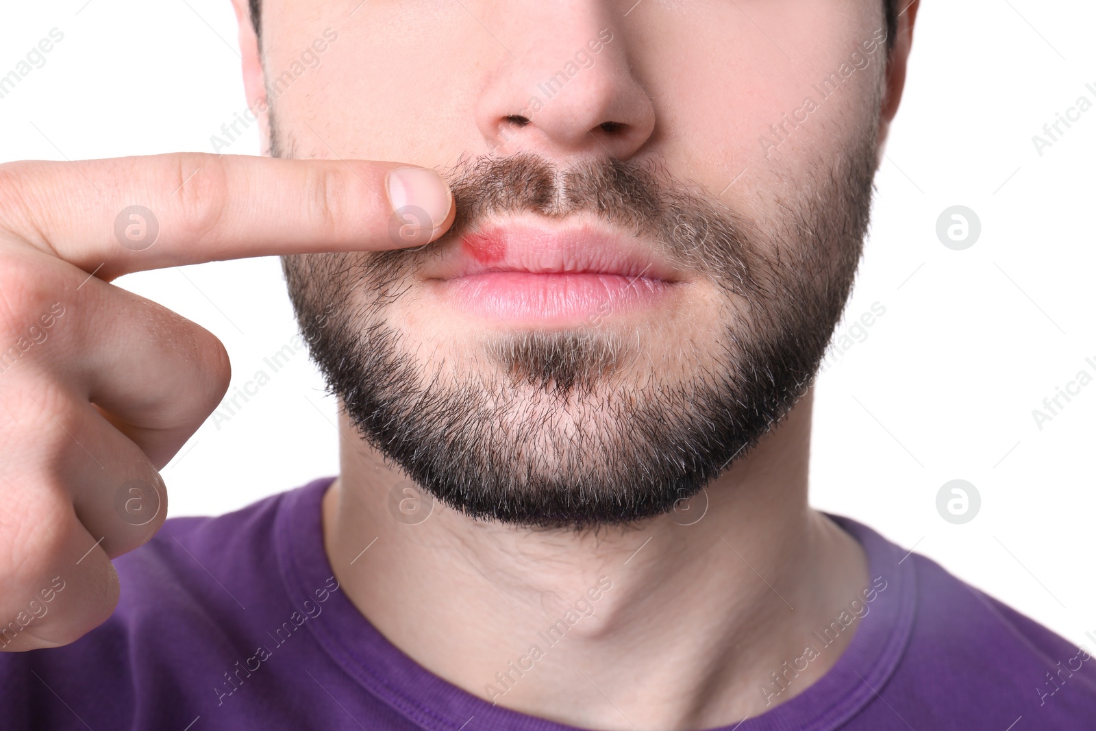 Photo of Young man pointing on lips against white background, closeup