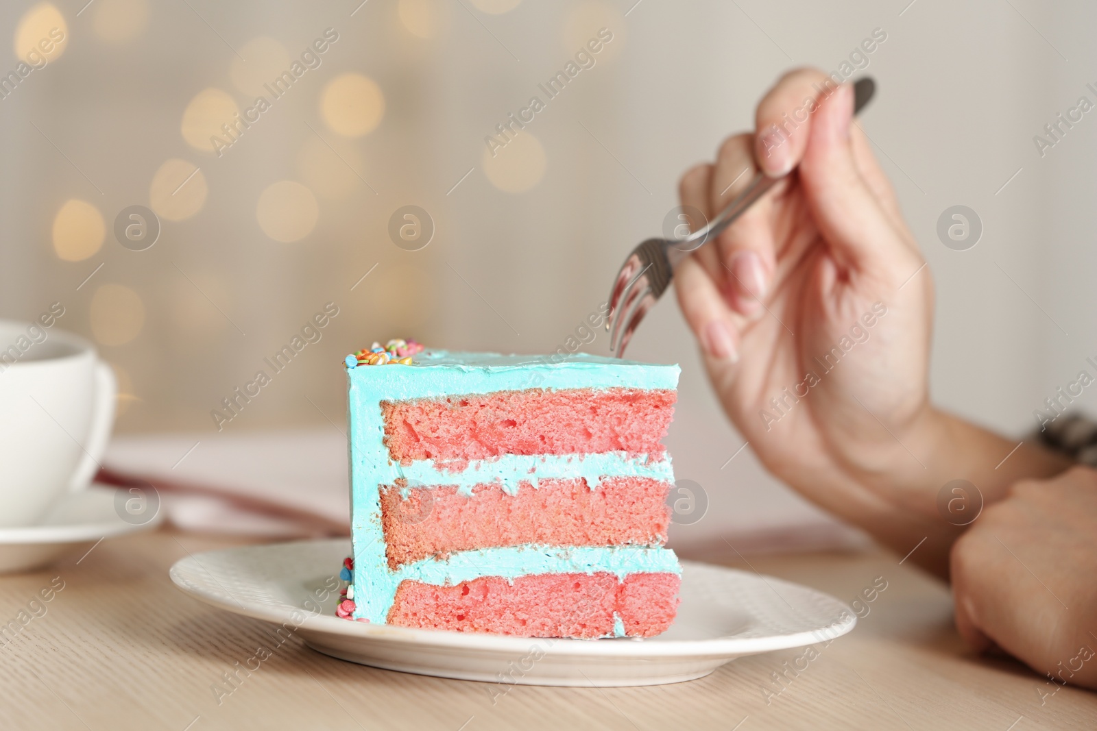 Photo of Woman eating fresh delicious birthday cake at table, closeup