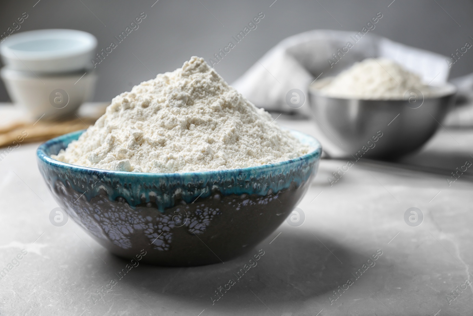 Photo of Ceramic bowl with flour on table