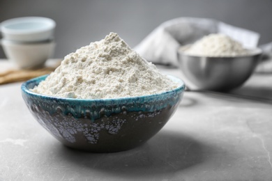 Photo of Ceramic bowl with flour on table