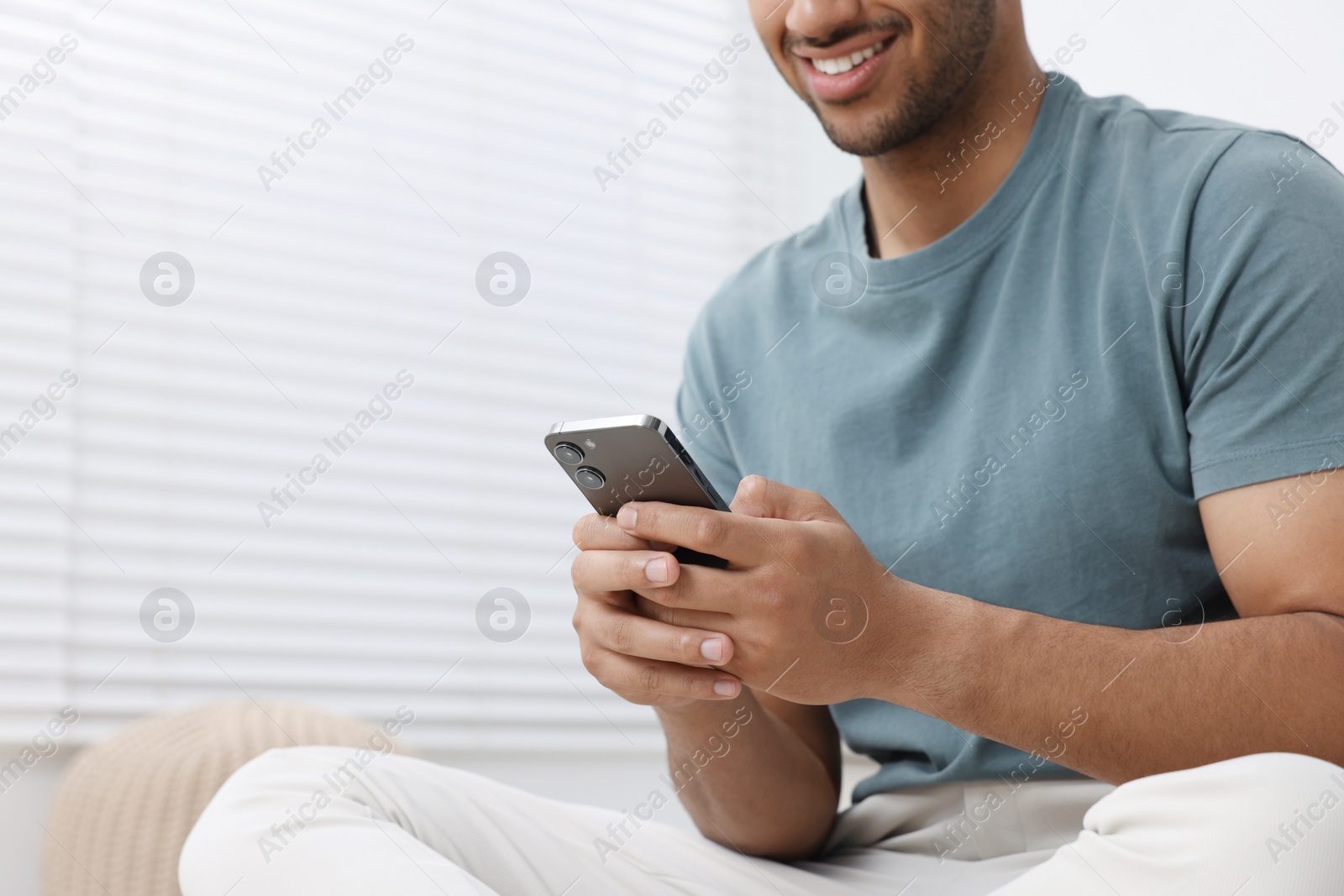 Photo of Man using modern mobile phone indoors, closeup. Space for text