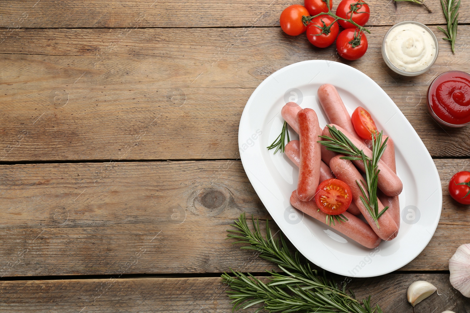Photo of Flat lay composition with vegetarian sausages and vegetables on wooden table. Space for text