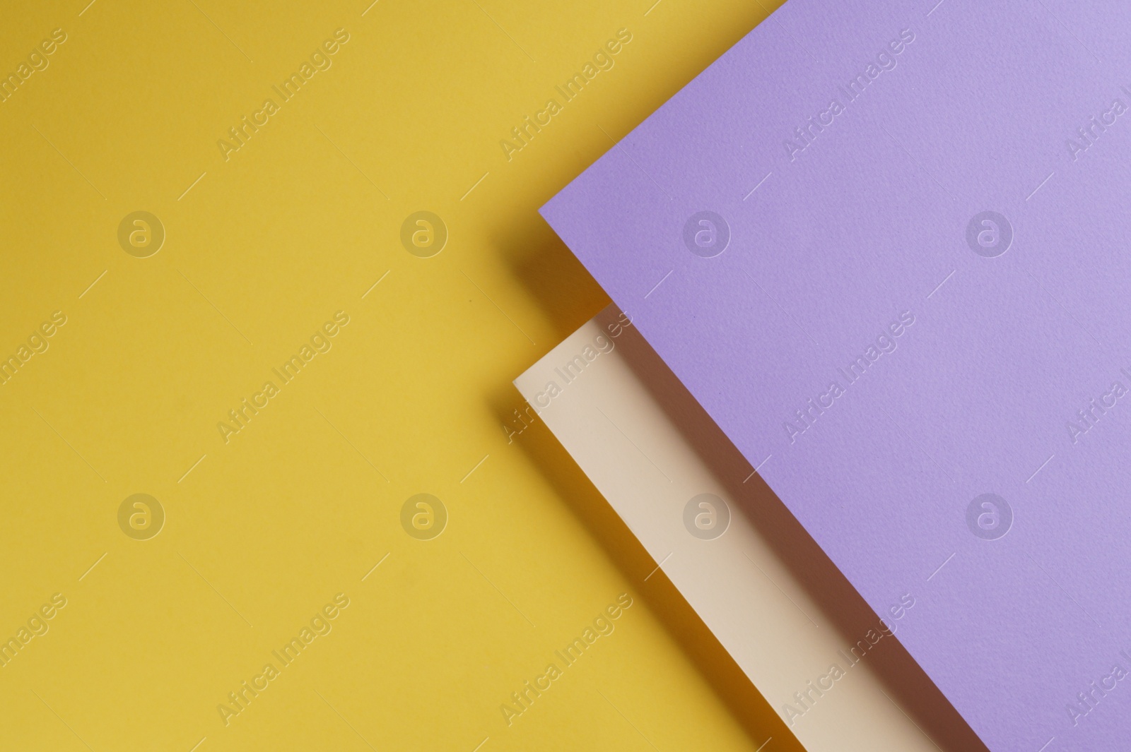 Photo of Colorful paper sheets on yellow background, top view. Space for text