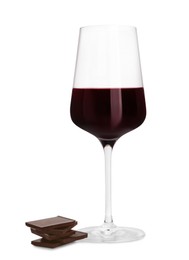 Photo of Glass of red wine and delicious chocolate pieces on white background