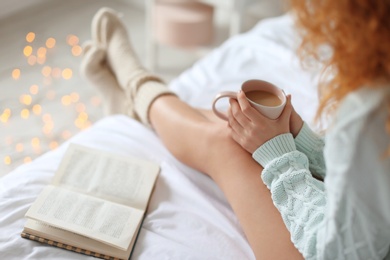 Photo of Young woman with sexy legs resting on bed at home