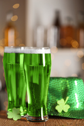 Photo of Green beer, clover and hat on wooden counter. St.Patrick's Day celebration