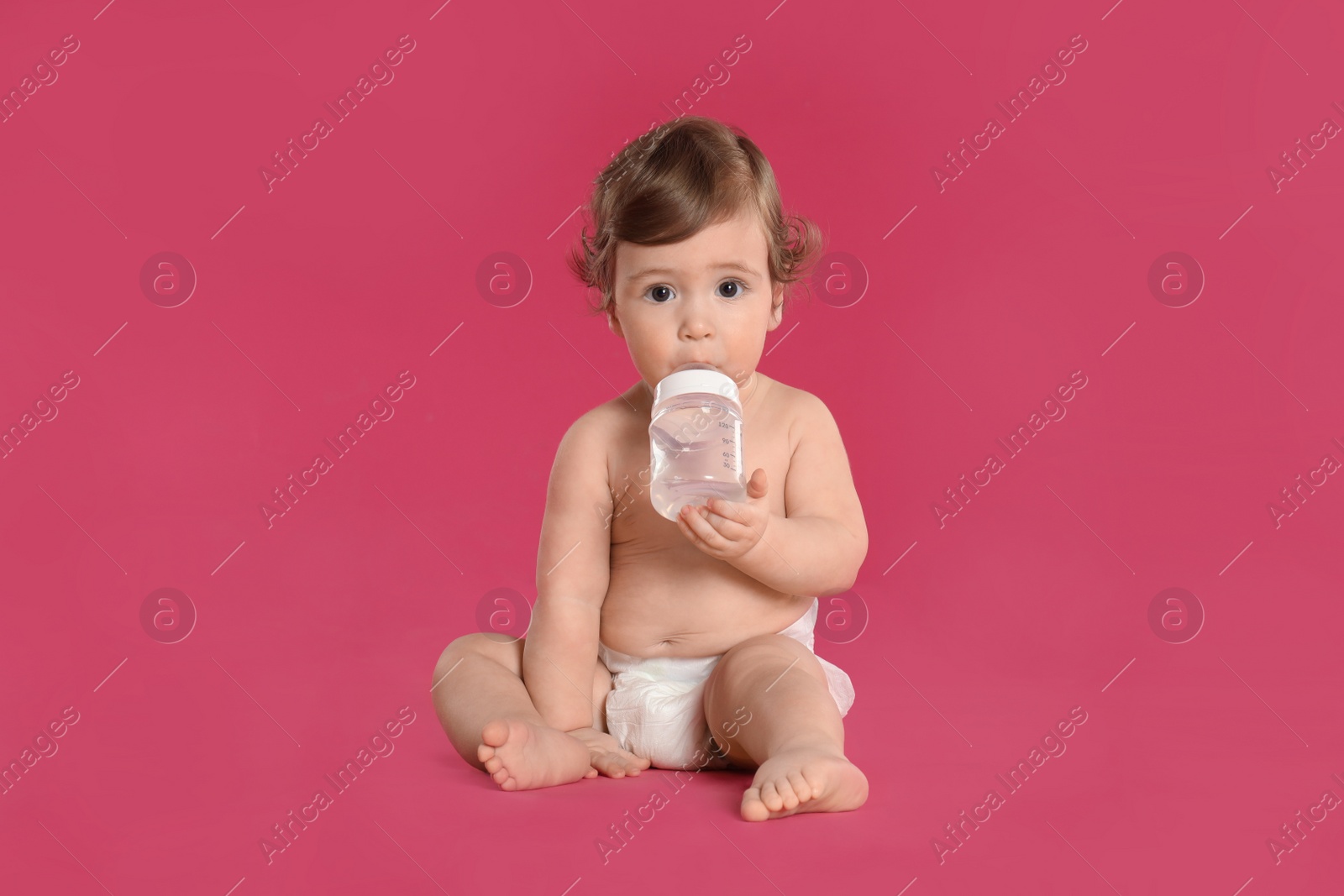 Photo of Cute little baby in diaper on pink background