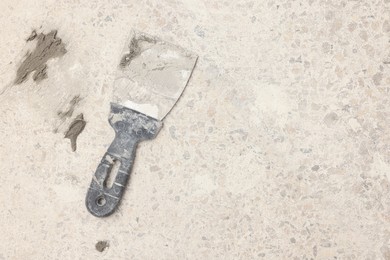 Photo of Spatula with adhesive mix on floor, above view. Space for text