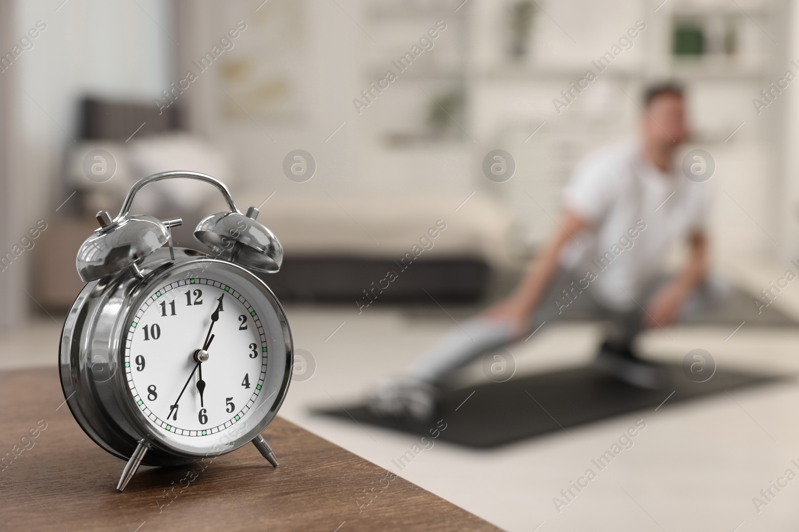 Photo of Man doing morning exercise on fitness mat at home, selective focus. Space for text