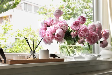 Photo of Beautiful pink peonies in vase on window sill. Interior design