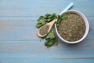 Photo of Dried parsley and fresh leaves on light blue wooden table, flat lay. Space for text