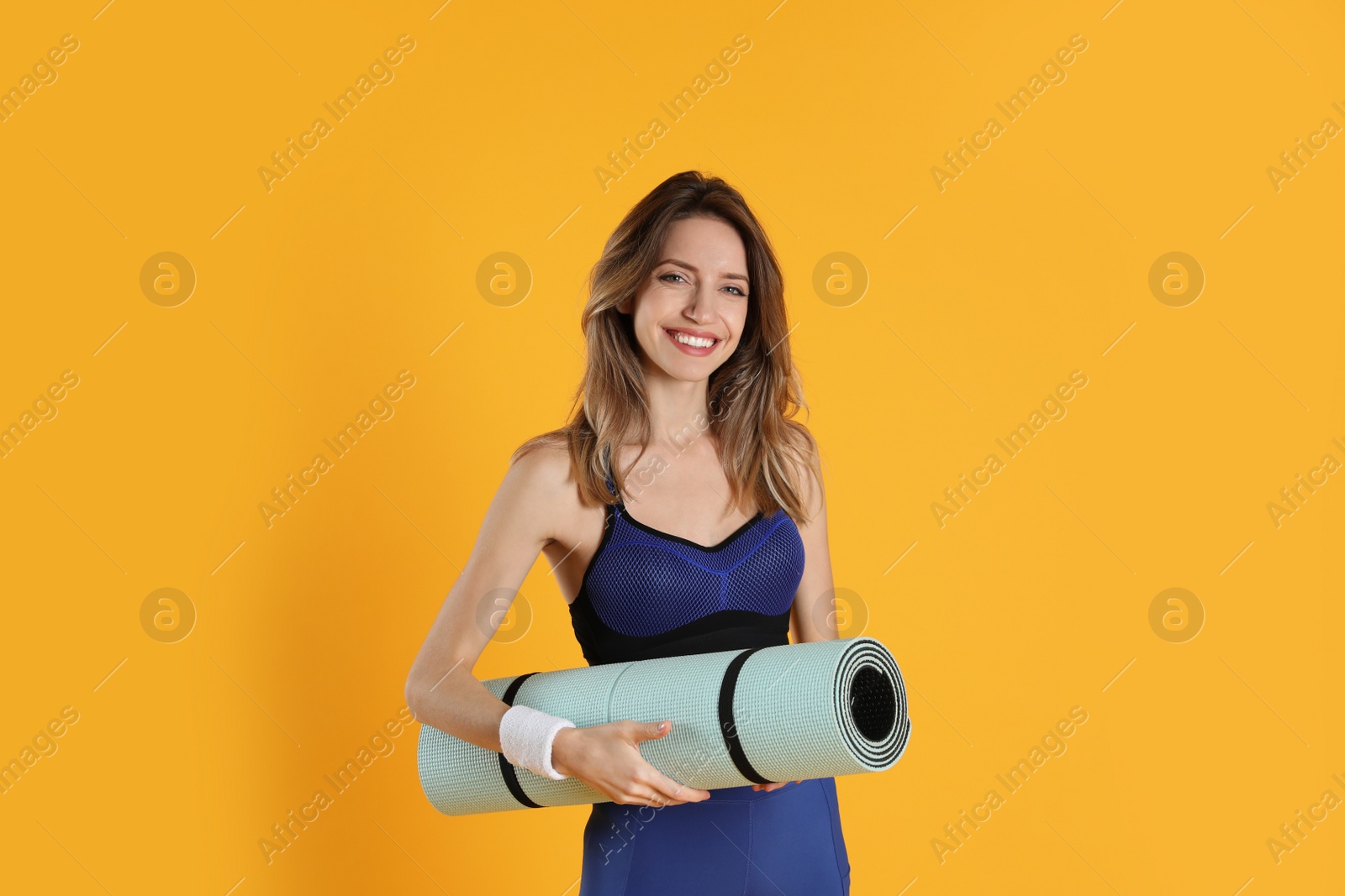 Photo of Beautiful woman with yoga mat on yellow background