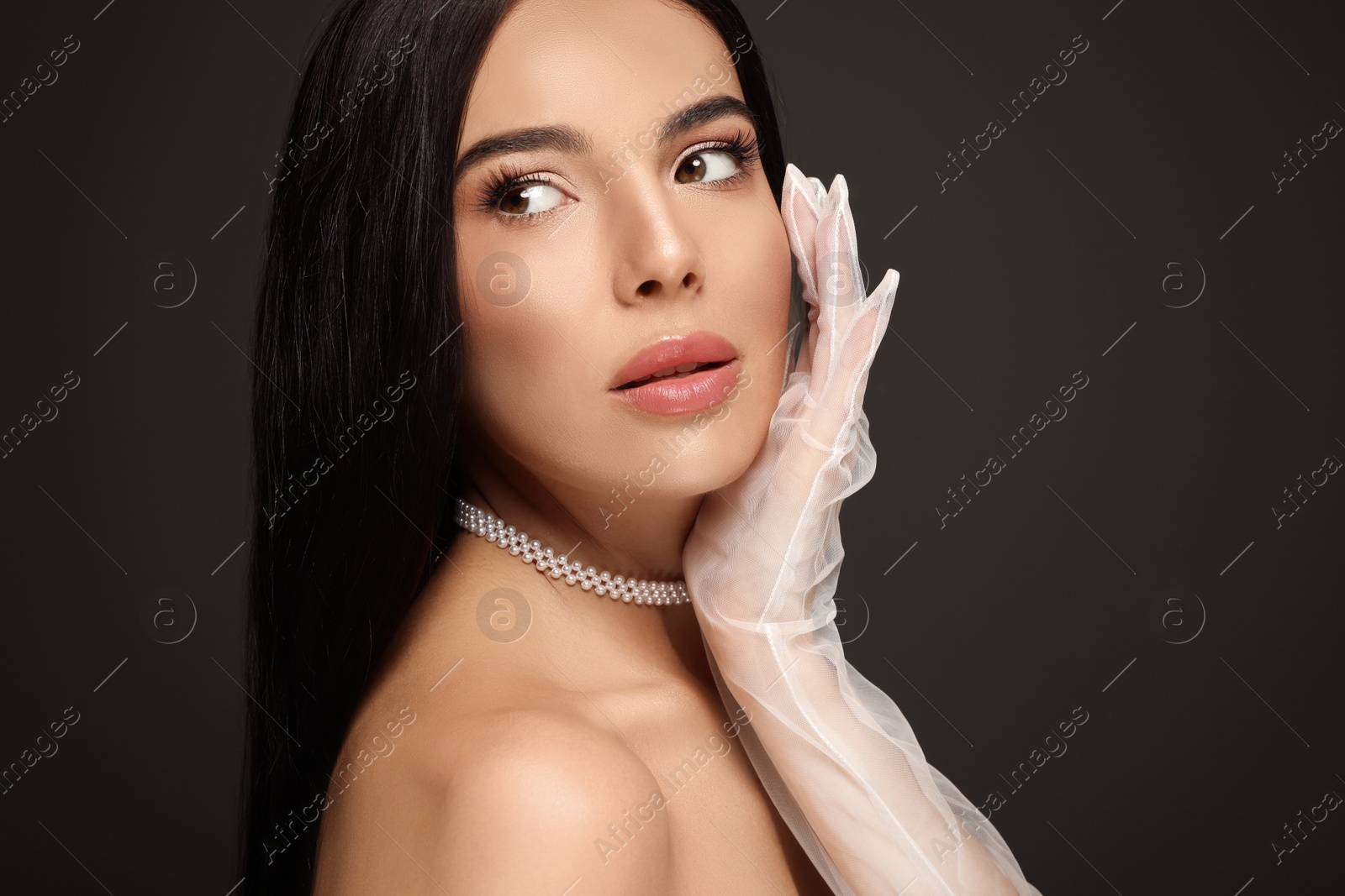 Photo of Portrait of young woman with beautiful makeup on black background