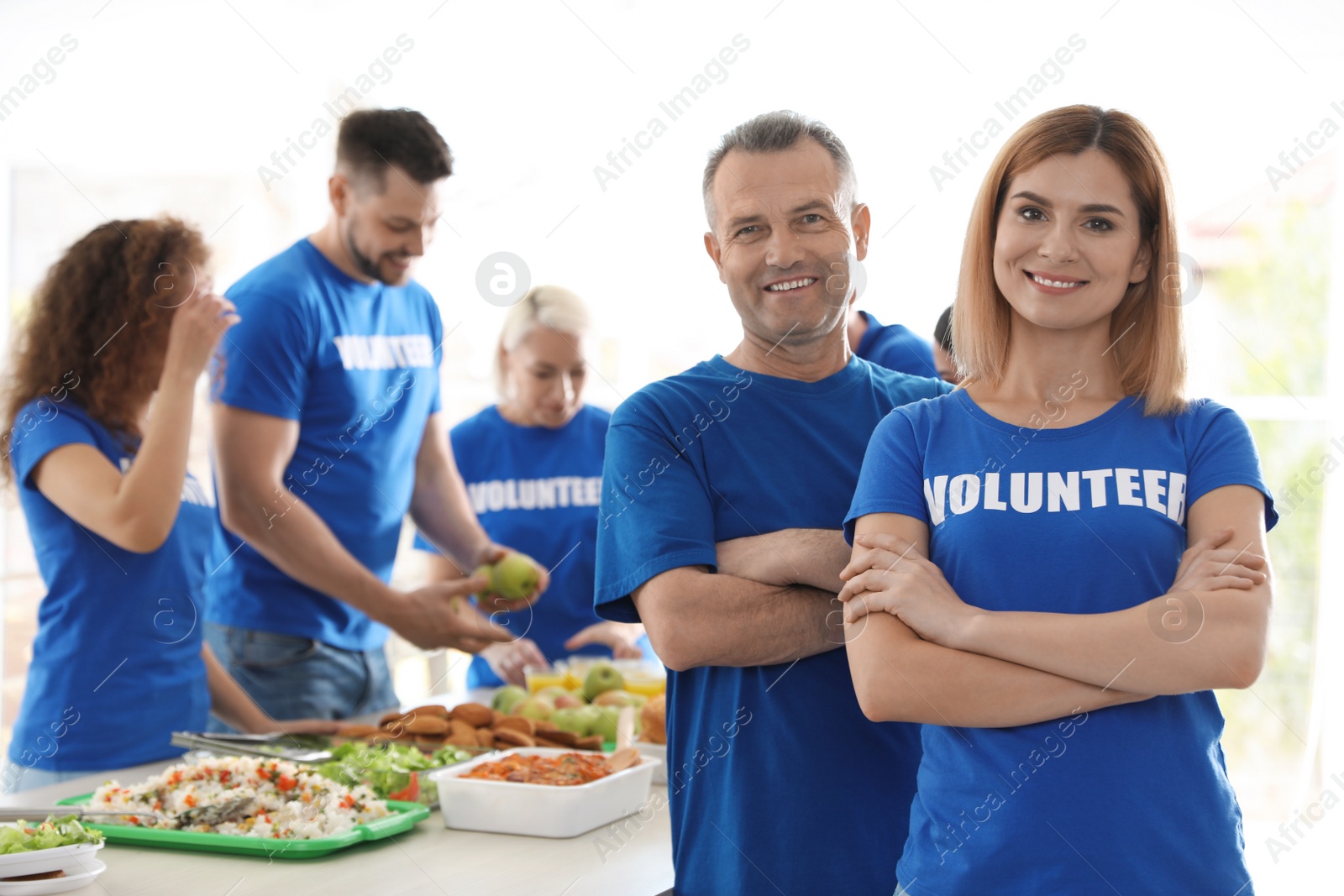 Photo of Team of volunteers near table with food indoors