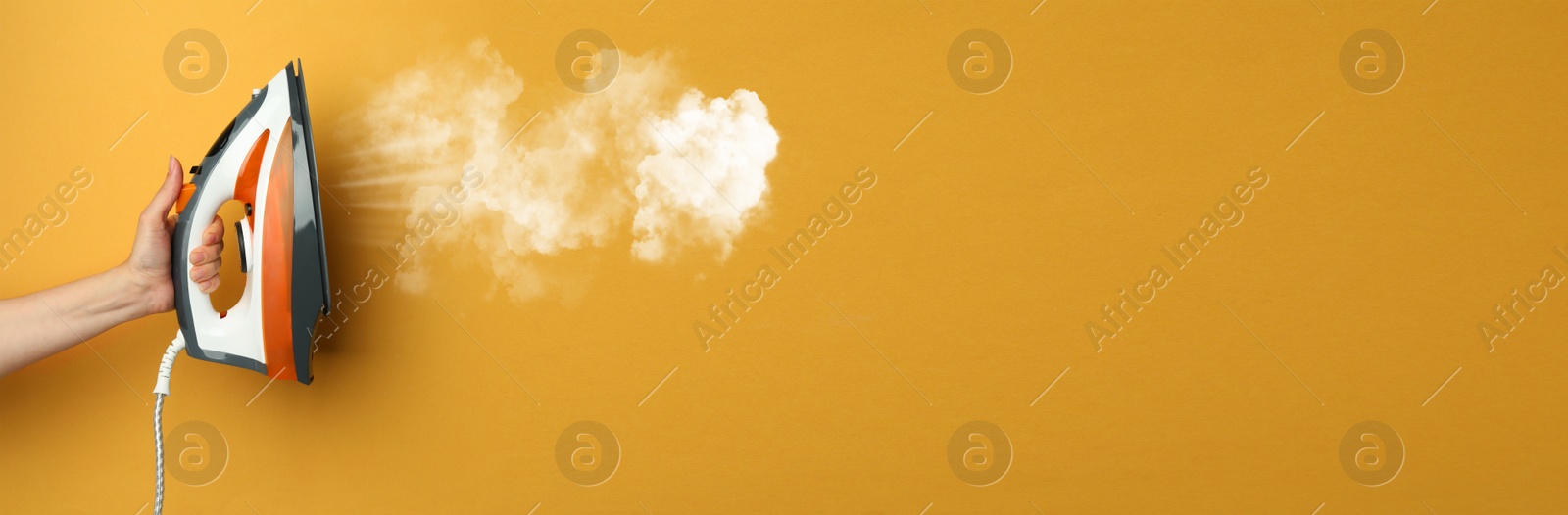 Image of Woman with iron on orange background, closeup. Banner design with space for text