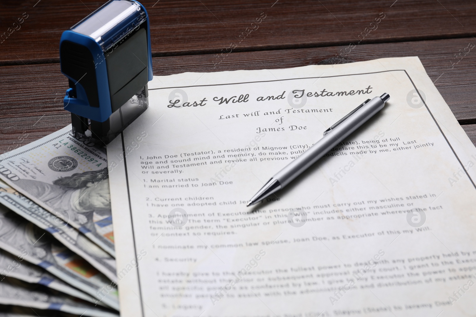 Photo of Last Will and Testament, stamp, dollar bills and pen on wooden table, closeup