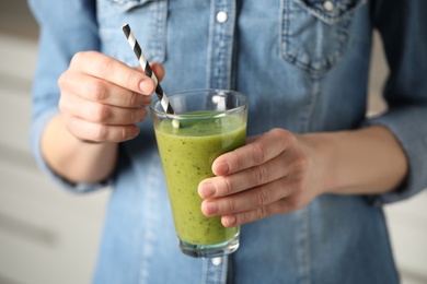 Photo of Woman with delicious kiwi smoothie indoors, closeup
