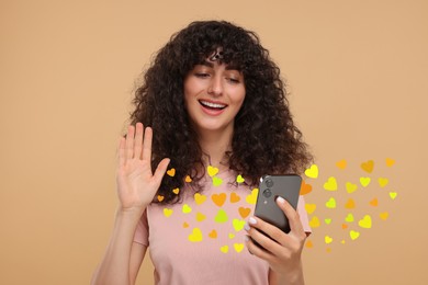 Image of Long distance love. Woman video chatting with sweetheart via smartphone on dark beige background. Hearts flying out of device