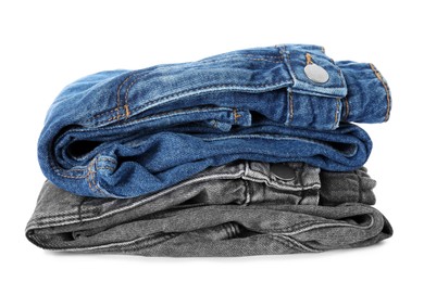 Stack of folded jeans on white background