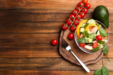 Photo of Delicious salad with chicken, vegetables and spinach on wooden table, flat lay. Space for text