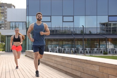 Photo of Healthy lifestyle. Happy couple running outdoors, space for text