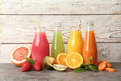 Bottles with tasty juices and ingredients on table