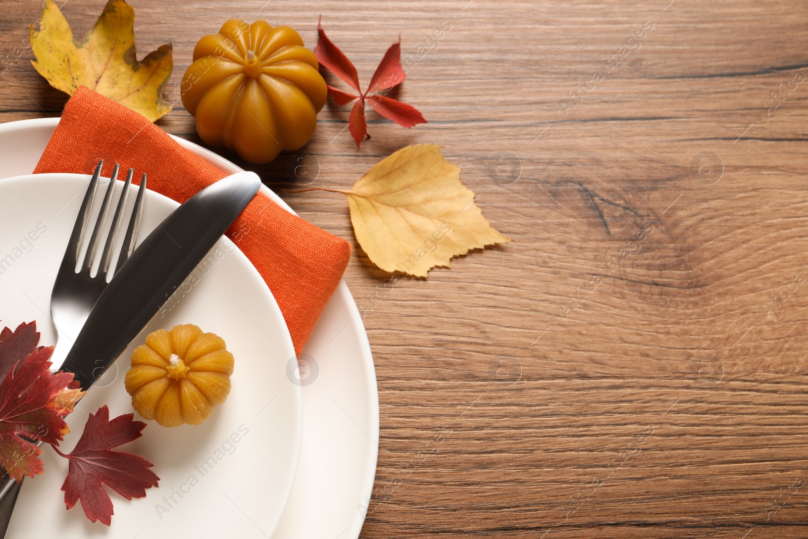 Photo of Festive table setting with autumn decor on wooden background, flat lay. Space for text