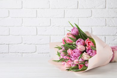 Photo of Bouquet of beautiful tulips on white wooden table. Space for text