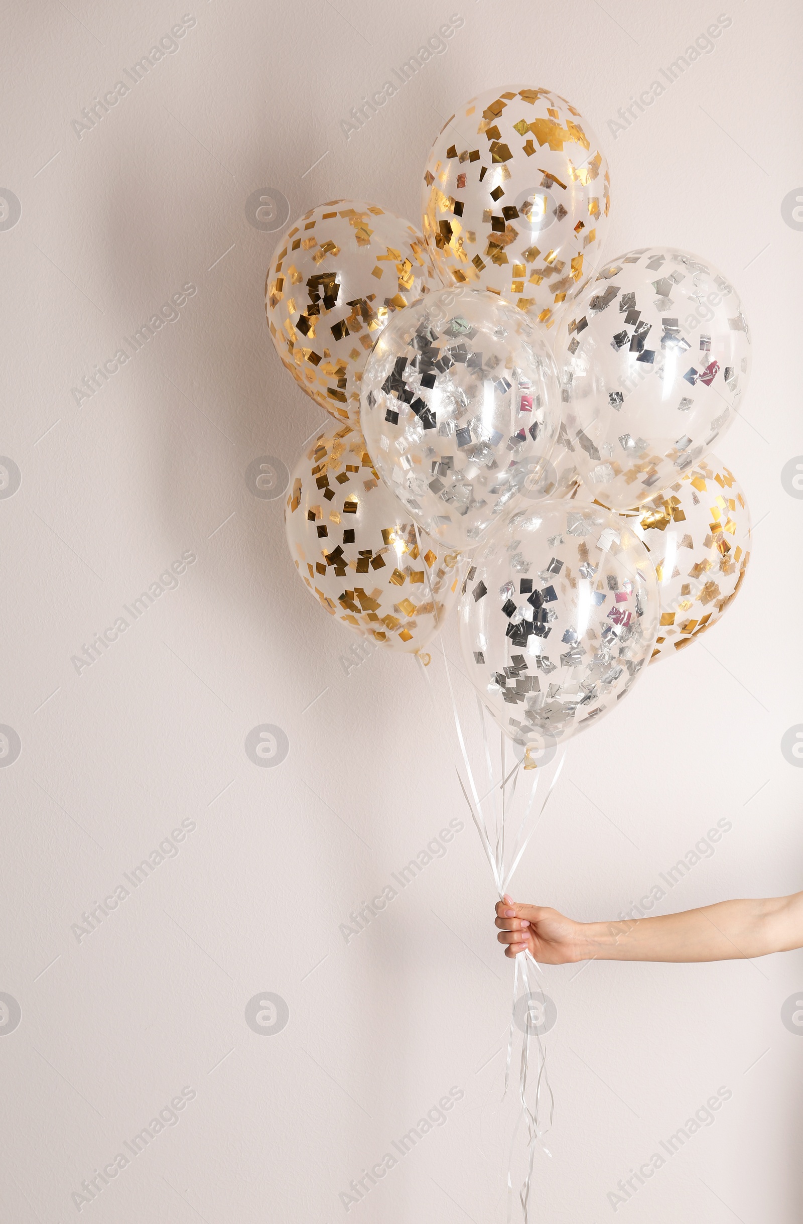 Photo of Woman holding bunch of balloons on white background, closeup