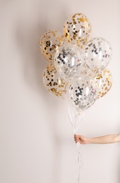 Photo of Woman holding bunch of balloons on white background, closeup