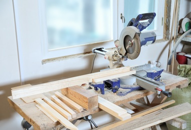 Photo of Modern circular saw in carpentry shop. Working space