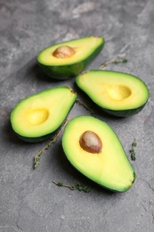 Fresh yummy avocado pieces on grey table