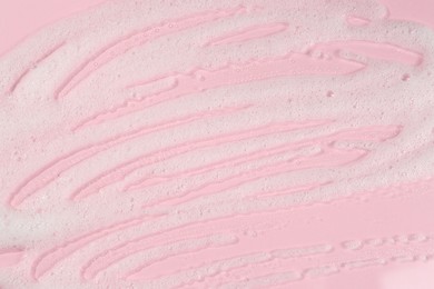 Cleansing foam on pink background, top view. Cosmetic product