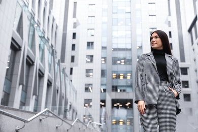 Photo of Portrait of beautiful woman in stylish suit on city street. Space for text