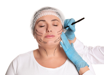 Photo of Doctor drawing marks on woman's face for cosmetic surgery operation against white background. Double chin problem