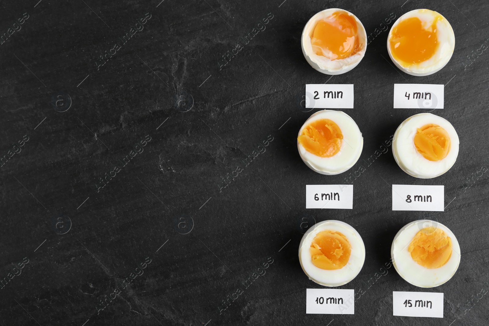 Photo of Different cooking time and readiness stages of boiled chicken eggs on black table, flat lay. Space for text