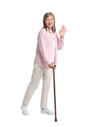 Senior woman with walking cane waving on white background