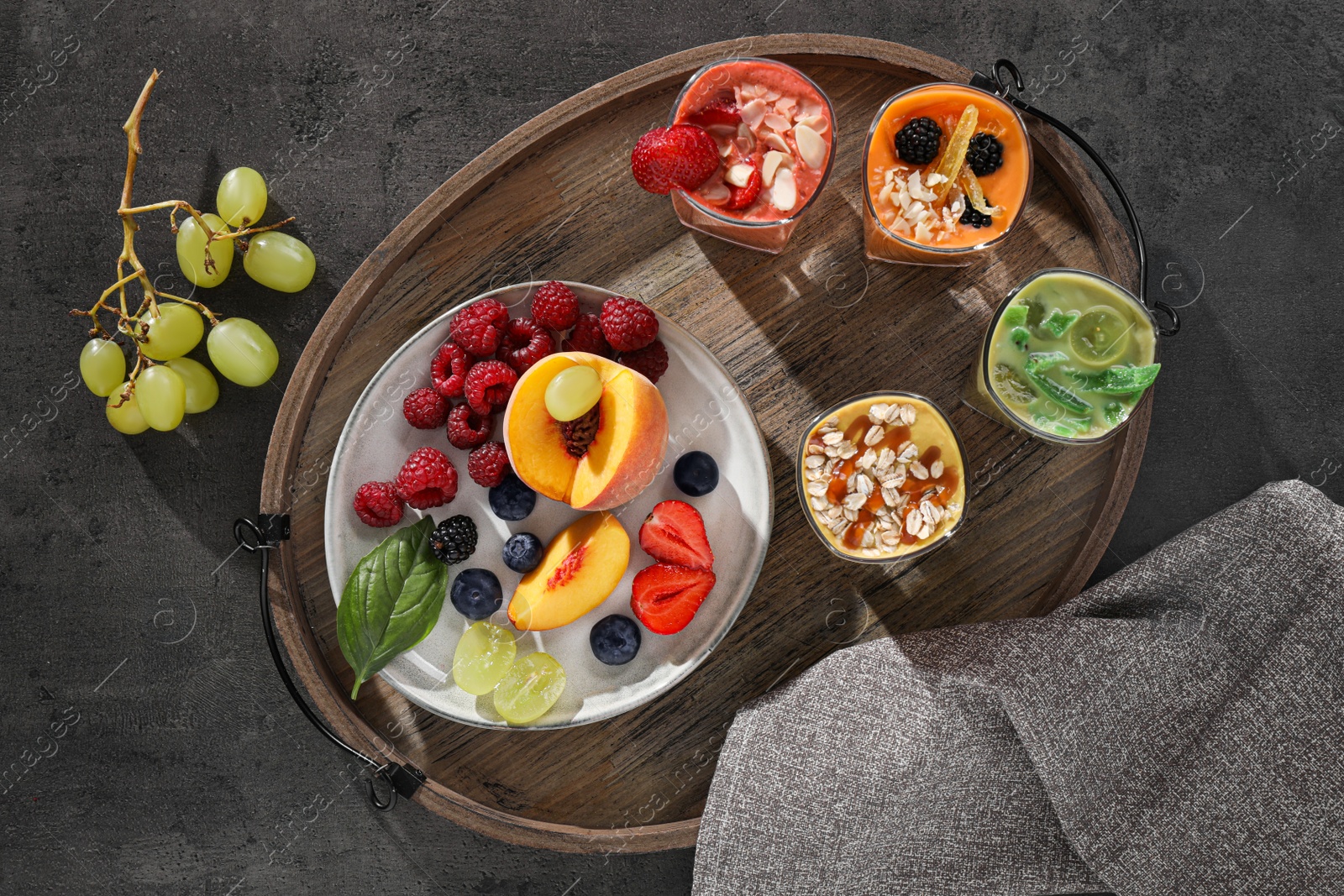 Photo of Many different delicious smoothies and ingredients on grey table, flat lay