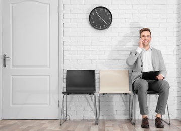 Photo of Young man waiting for job interview, indoors